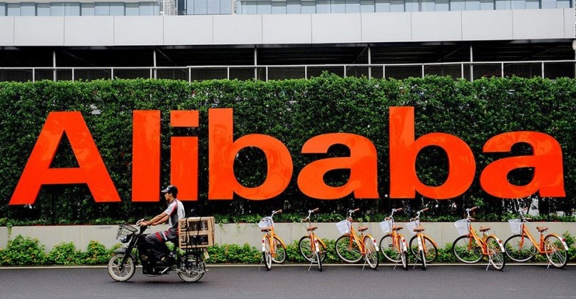 person cycling in front of alibaba logo