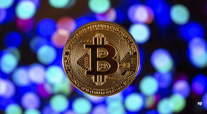 single bitcoin on blue background