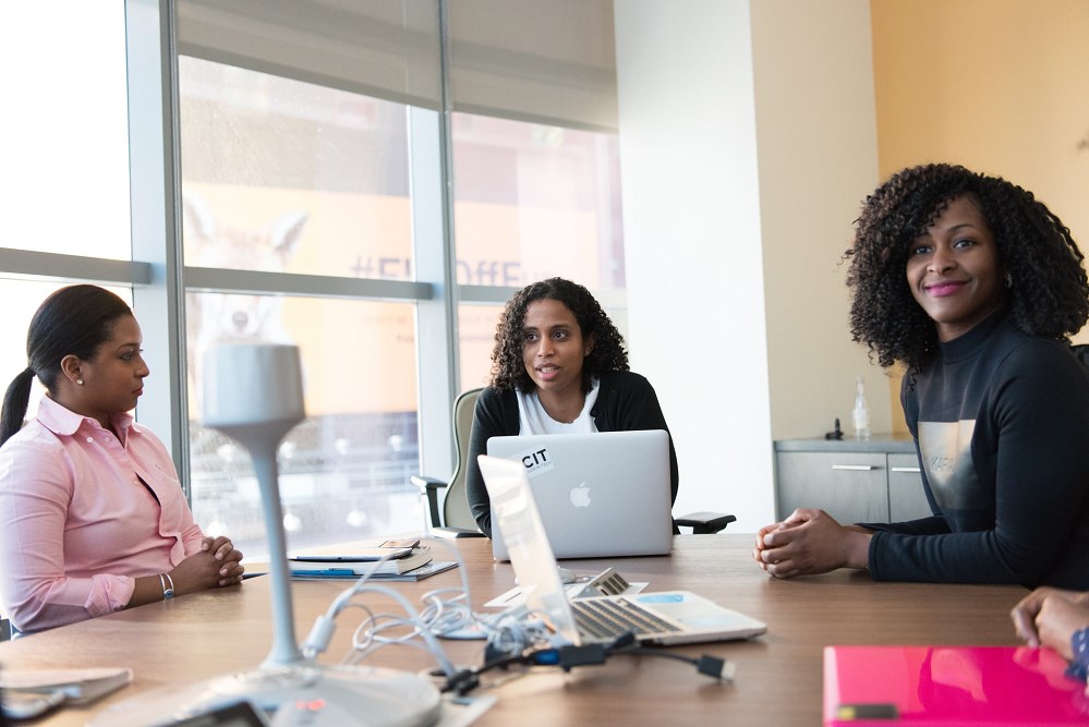 Black women in a boardroom talking