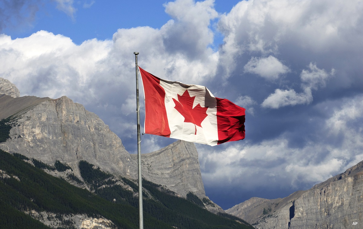 Canadian flag in front of mountains