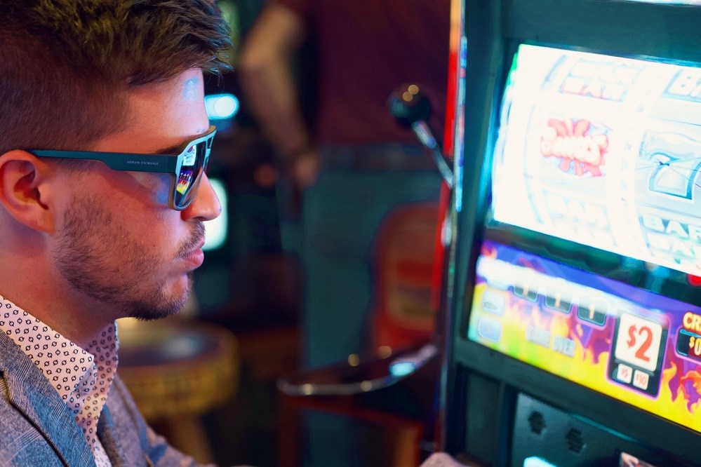 Guy with sunglasses at a slot machine