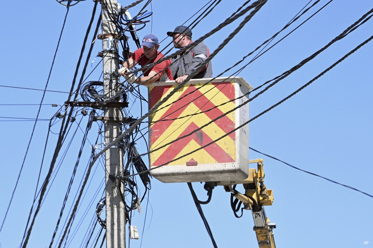 Travailleurs sur un poteau électrique