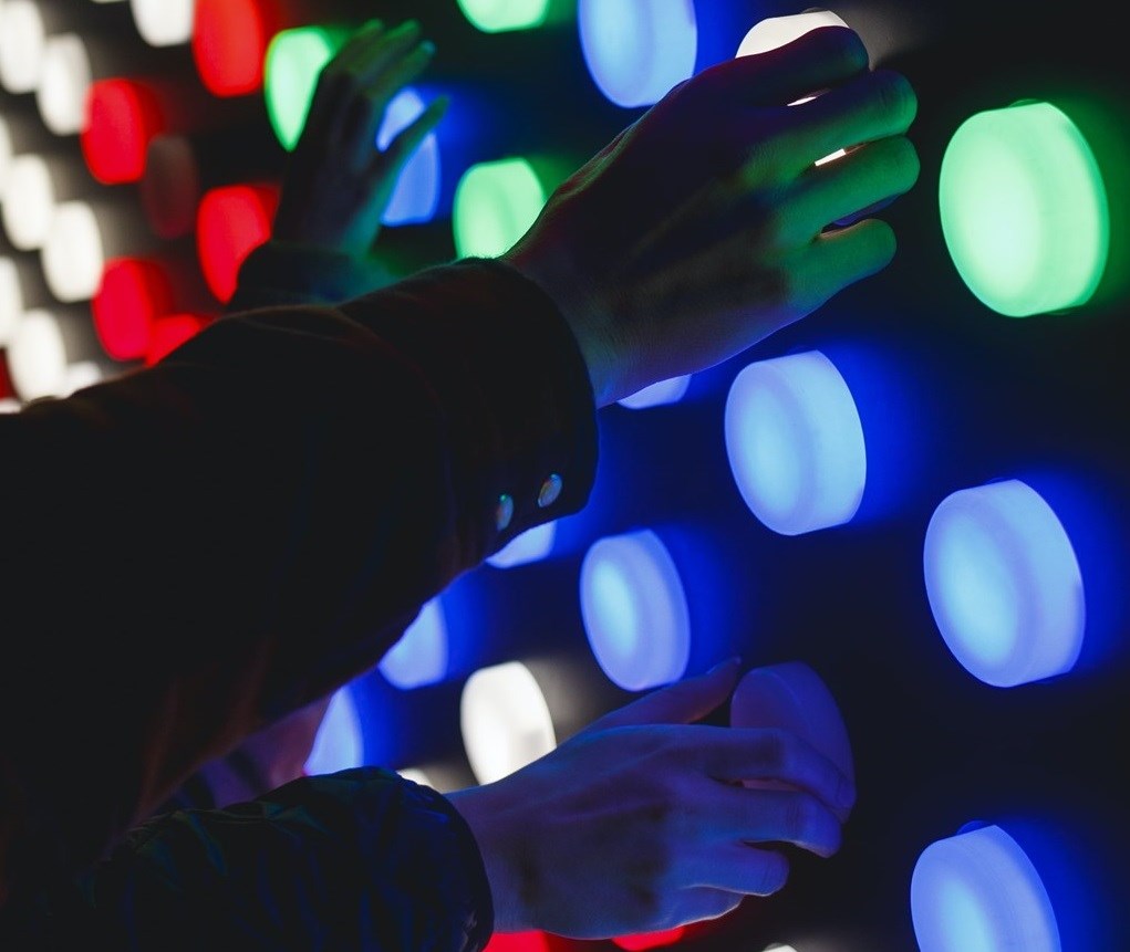 Hands touching multicoloured lights