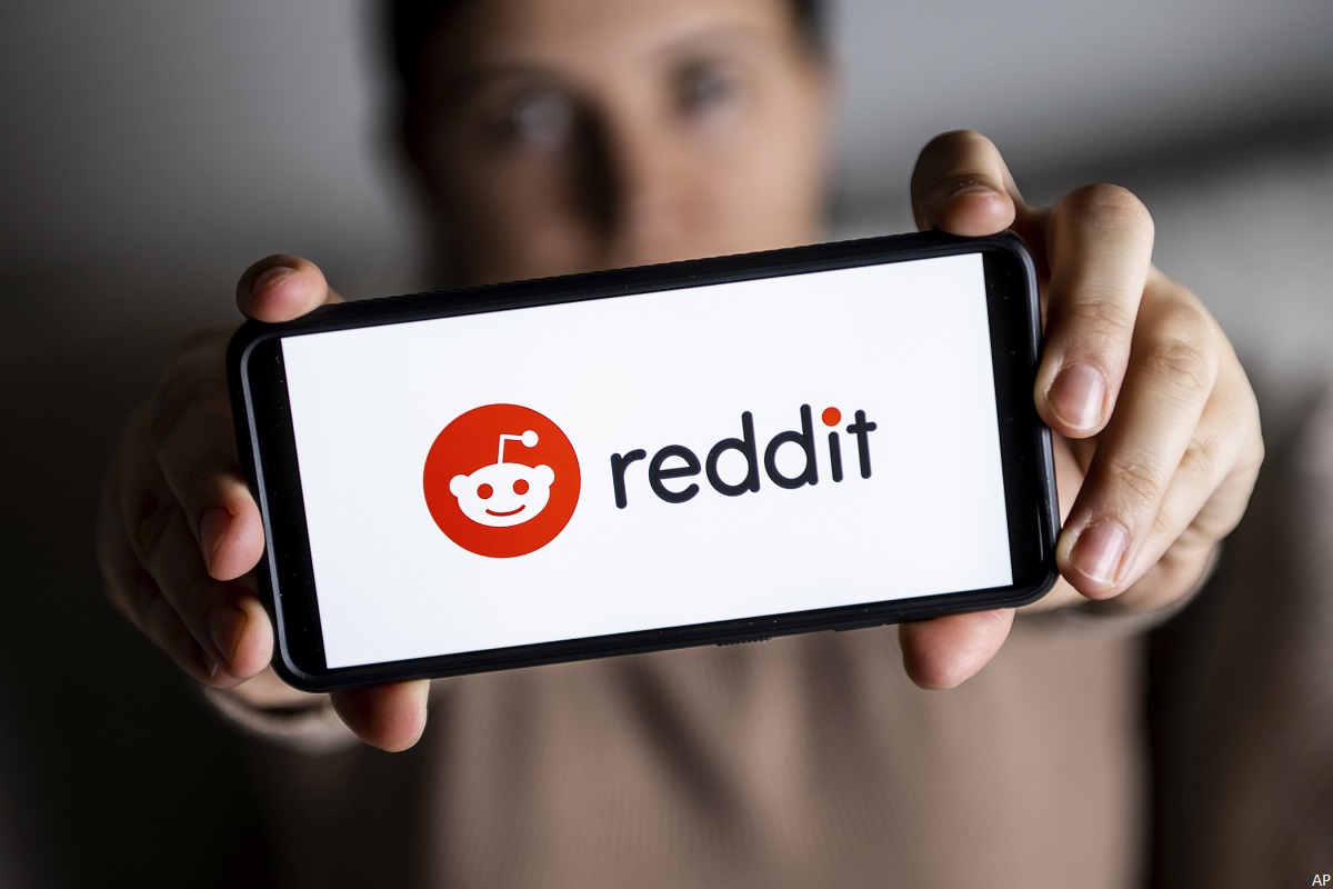 Person showing Reddit logo on a phone