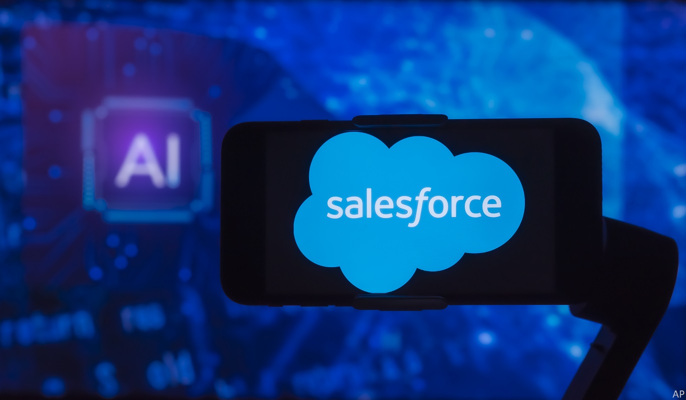 In this photo illustration, the logo of Salesforce is seen displayed on a mobile phone screen with AI (artificial intelligence) written in the background. 