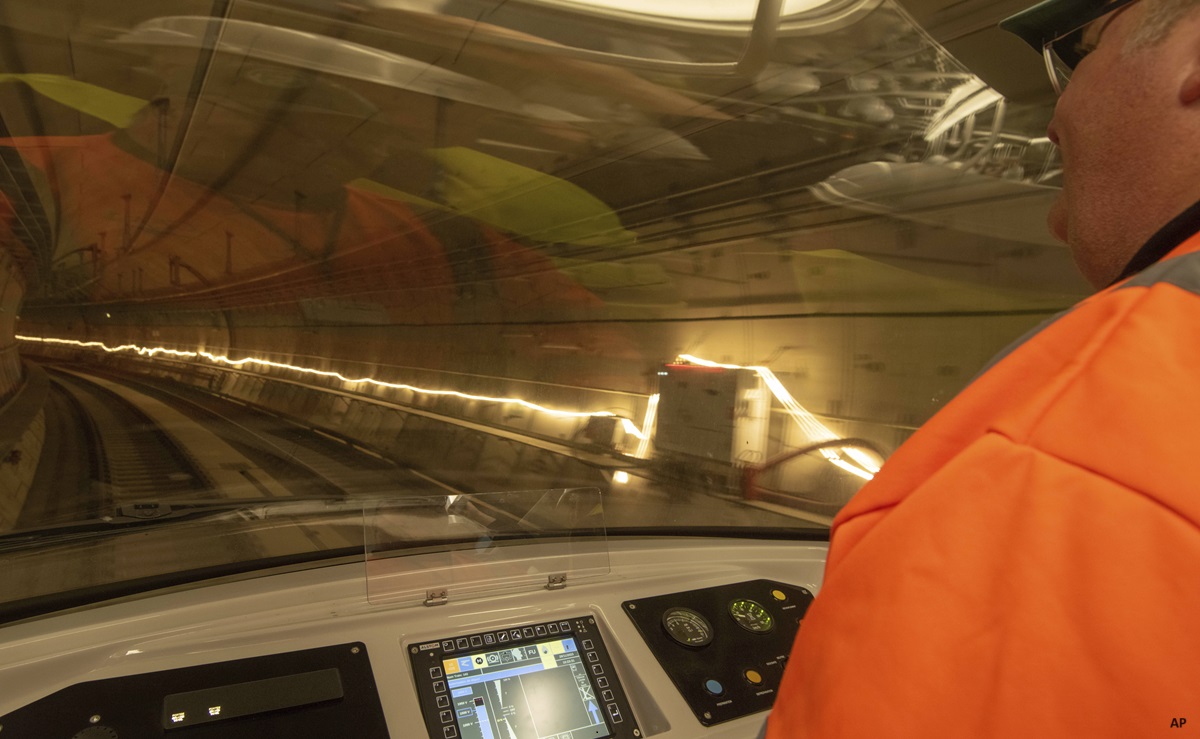 Train engineer operating a train moving forwards in a tunnel