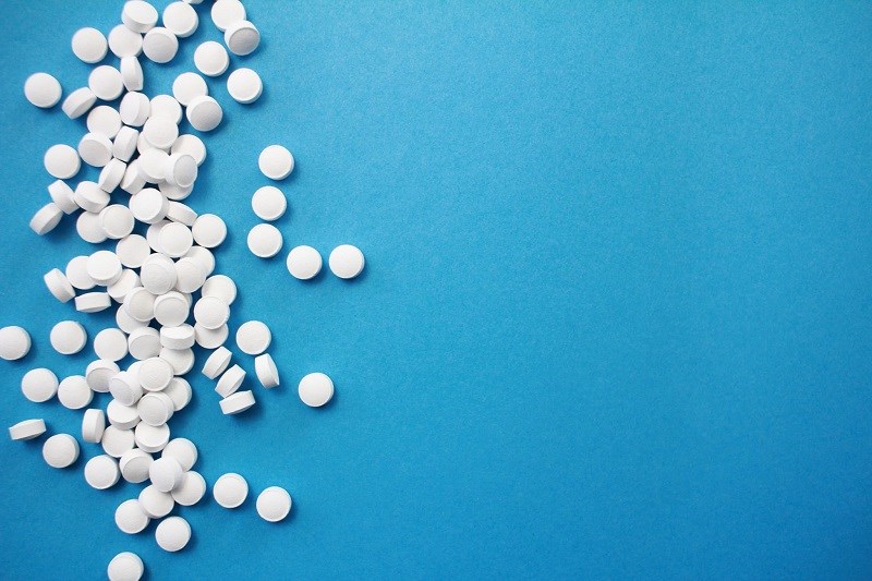 White pills blue background
