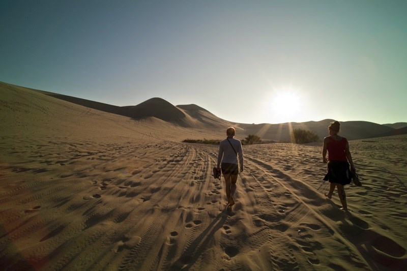 Women walking on sand into distance