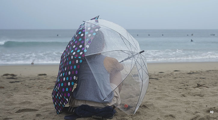 a woman on a beach in the rain