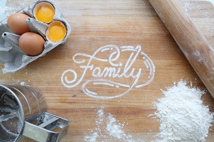 The word family written in flour on a cutting board