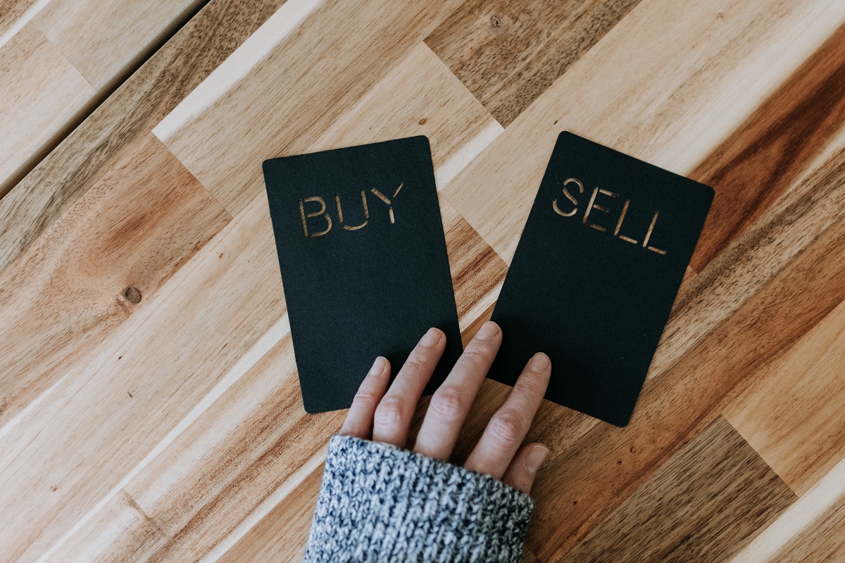 Cards that say "buy" and "sell" on a table