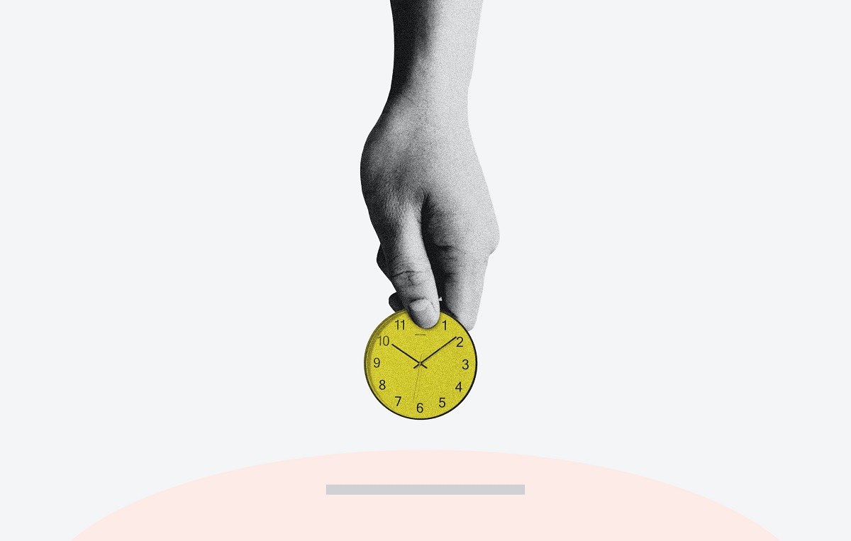 Hand putting clock, as if a coin, into a piggy bank