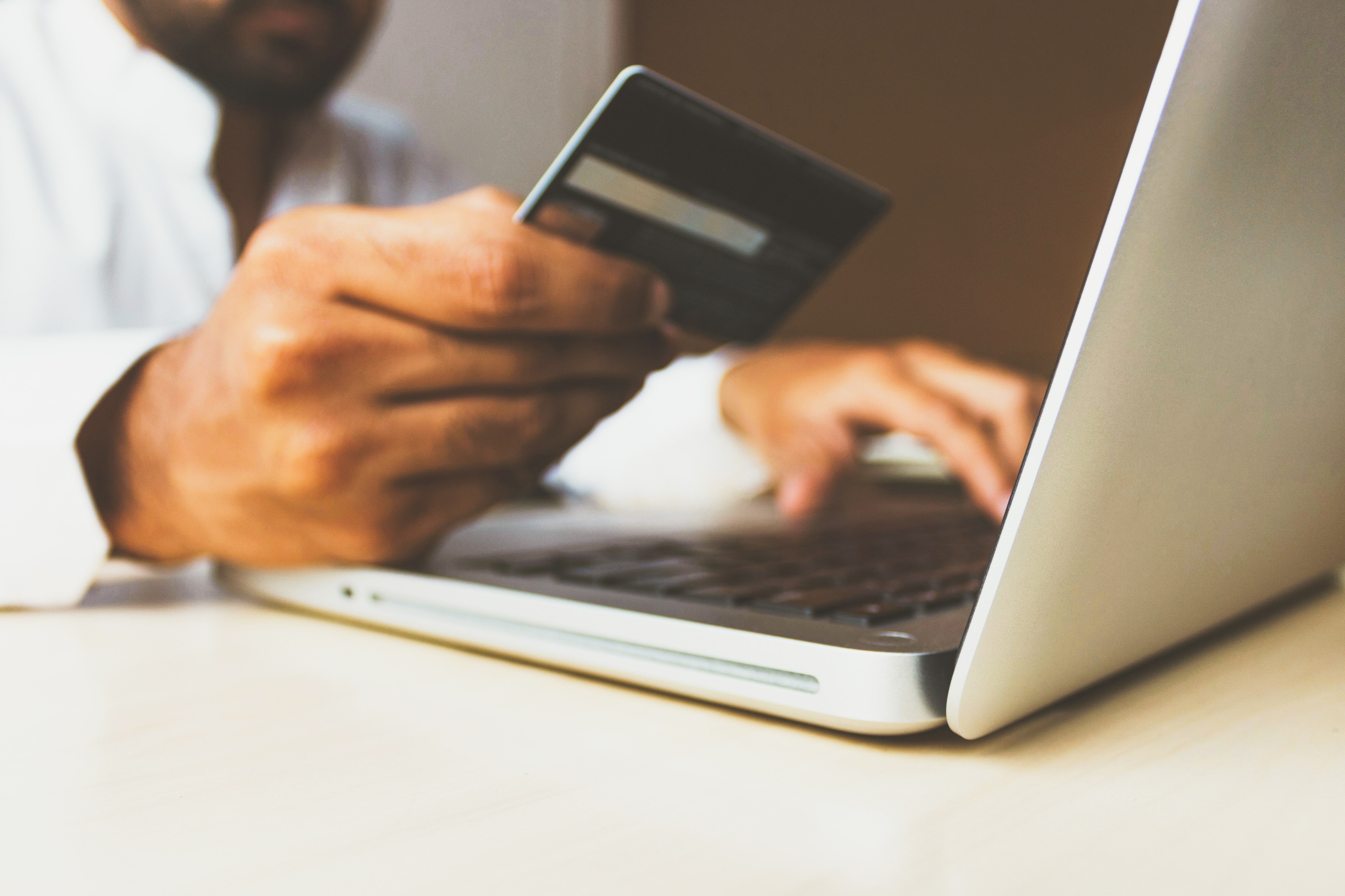 Person holding credit card at computer