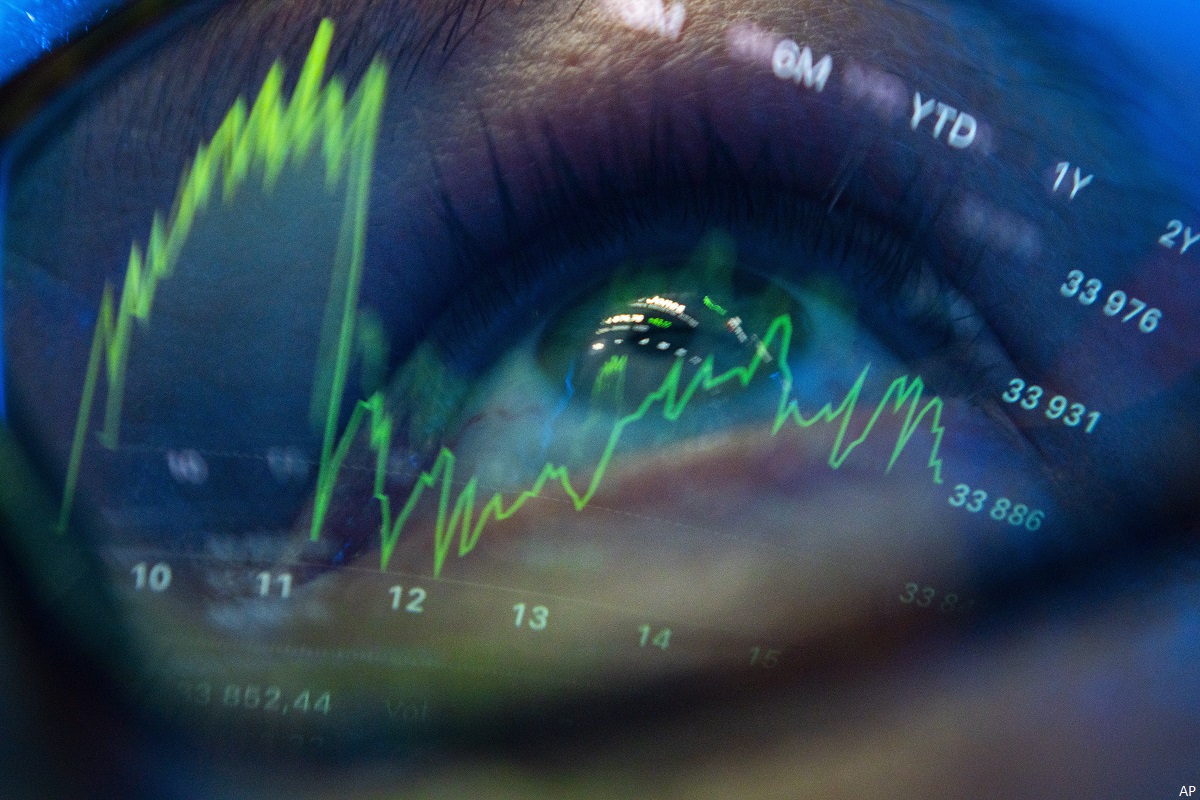 Dow Jones index graphs are seen reflected in a man&#39;s glasses