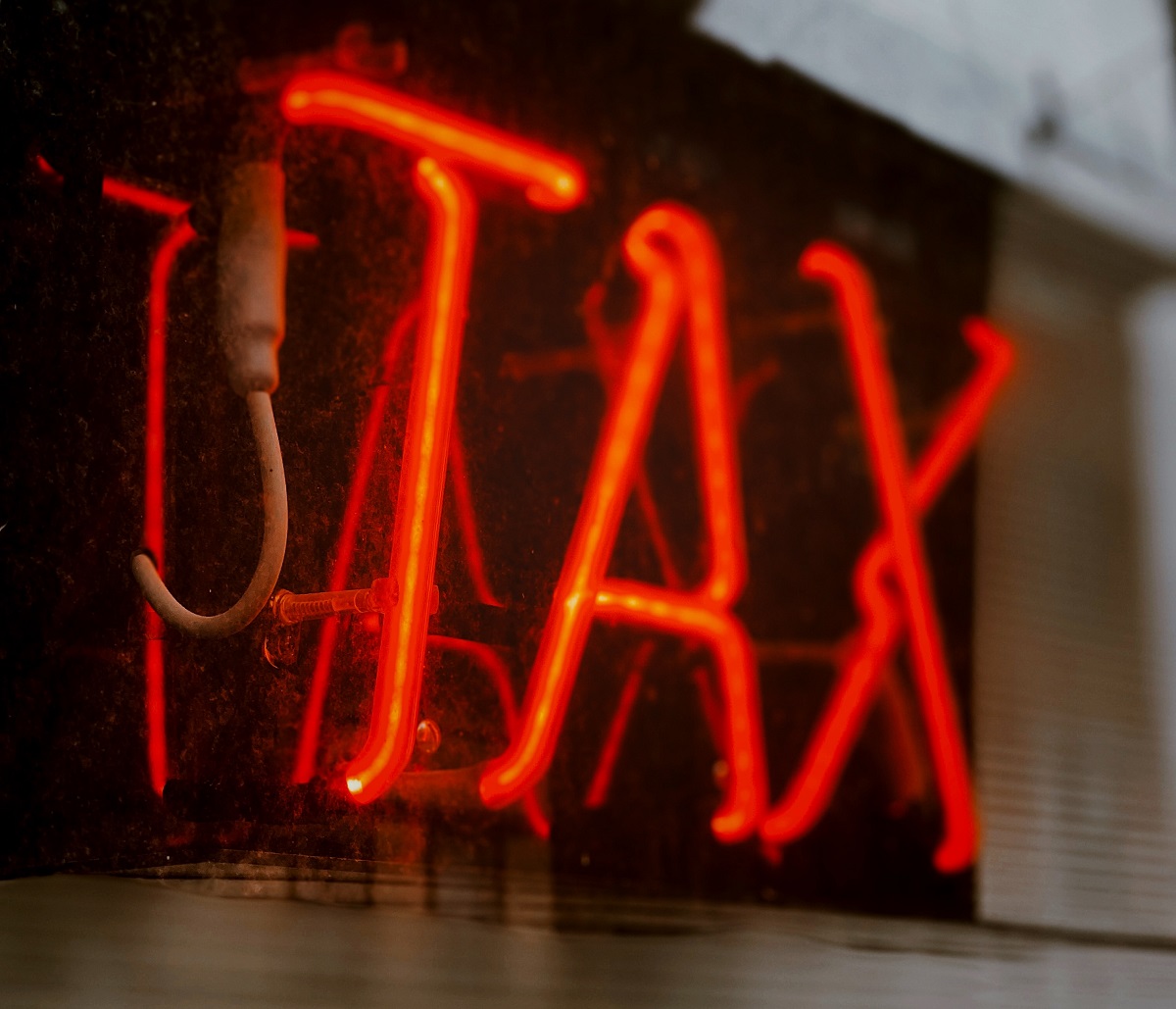 Red neon sign that says Tax
