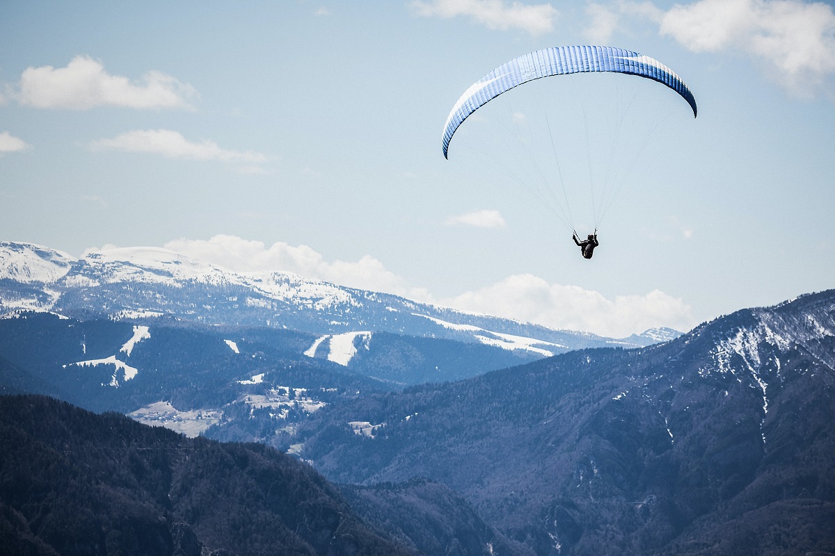 Paraglider soaring above mountains